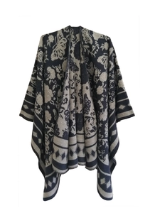 Detail of knit shawl featuring butterfly patterns and geometric diamond borders
