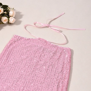 Dettaglio del tessuto di paillettes rosa e dei sottili lacci per gonne a fessura da festa