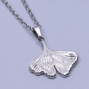Macro shot of silver ginkgo leaf pendant with polished metallic surface and fine chain
