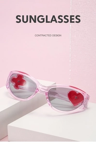 Detail of pink heart-shaped Y2K sunglasses with clover pattern and jelly texture