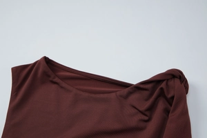 Close-up of dark coffee sleeveless top featuring twisted knot detail at the neckline