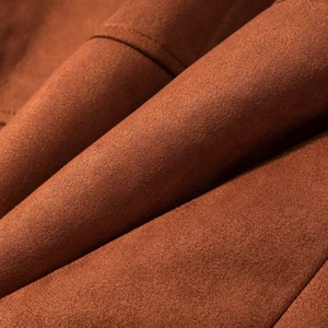 Detailed macro view showing the soft texture of premium reddish-brown faux suede fabric