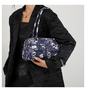 Detail of dark blue handbag with skull and rose print and magnetic buckle pockets