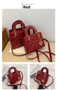 Detail view of red heart-embossed patent leather bridal handbag with heart charm