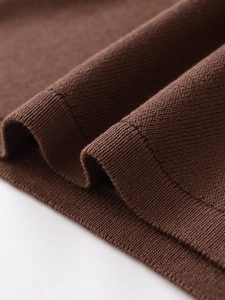 Gros plan sur la texture du tricot marron café avec des détails de couture professionnelle