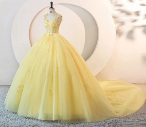 Close-up of a yellow ball gown with detailed sequin lace and tiered mesh skirt