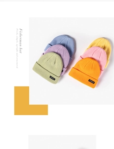 Flat lay of colorful knit fisherman hats in candy colors with woven logo labels