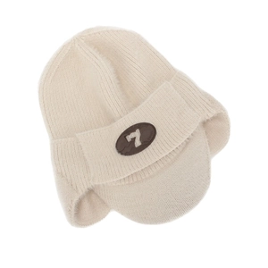 Vue détaillée d'un bonnet en tricot beige avec cache-oreilles, visière et écusson.