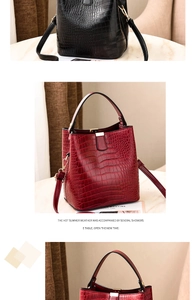 Detail of crocodile pattern texture and golden hardware on black and wine red bucket bags