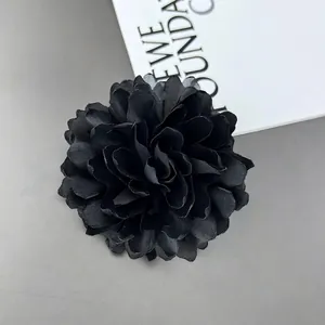 Detailed macro view of 10cm layered black fabric chrysanthemum flower with silky texture