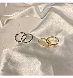 Orecchini a cerchio stile francese in oro e argento su elegante tessuto di seta bianca