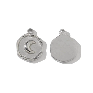 Macro detail of silver crescent moon embossed stainless steel charm pendants