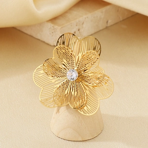 Détail d'une bague fleur vintage dorée avec une pierre centrale en zircone cubique