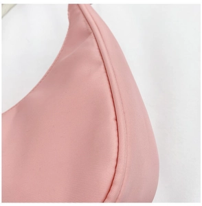 Close-up of pink nylon fabric texture and precise stitching on the crossbody bag