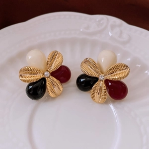 Close-up of vintage flower earrings with resin petals and a sparkling zircon center