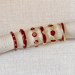 Set of six red and gold enamel floral rings with star and clover designs for women