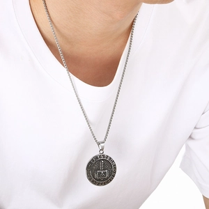 Close-up of silver Thor's Hammer pendant with Nordic runes on a professional model