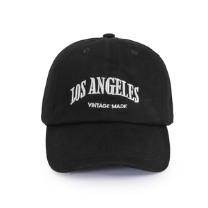 Macro detail of the white Los Angeles embroidery on a black washed cotton baseball cap