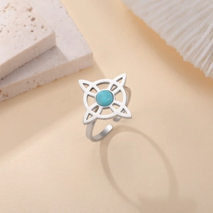 Vintage stainless steel witch knot ring featuring a turquoise stone on a beige background