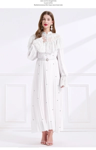 Détail du col en dentelle et ceinture perlée sur une robe longue plissée blanche chic