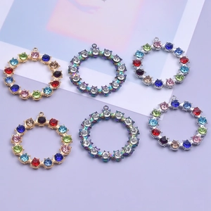 Macro detail of round 18k gold plated DIY charms with multicolored crystals for necklaces