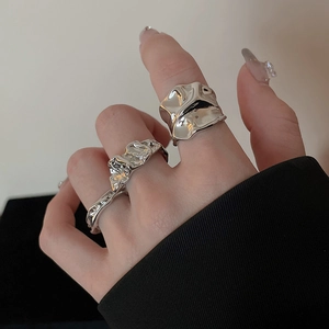 Detailed view of irregular liquid metal rings in polished silver finish on finger