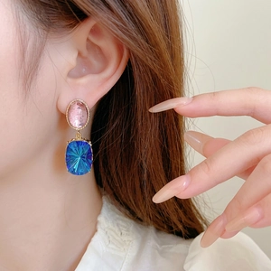 Vintage style gold-rimmed earrings with pink oval and blue square radiating gemstones