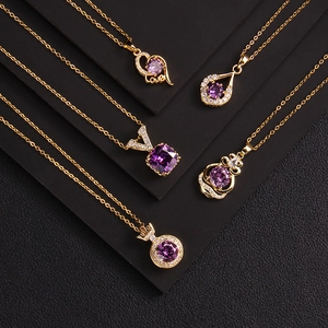 Five gold necklaces with purple zircon pendants in heart and drop shapes on black background