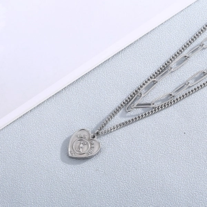 Detail of silver double-layered heart necklace with rotating yes no maybe arrow pointer