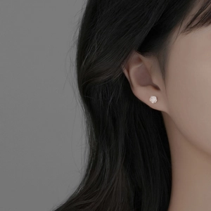 Elegant S925 sterling silver white rose stud earrings worn on model with dark background