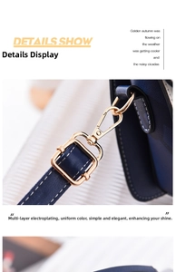 Detail of dark blue leather bag featuring gold hardware buckles and neat stitching