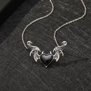 Collier punk gothique avec ailes de démon et pendentif coeur noir sur fond sombre