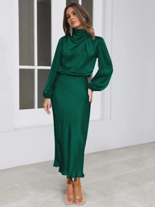 Detail of elegant dark green satin maxi dress with draped turtleneck and bishop sleeves