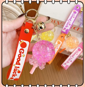 Detailed close-up of a pink resin lollipop keychain with glitter star filling and lucky strap