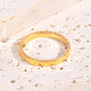Detail of 18K gold plated titanium steel ring with unique hammered texture on stone base