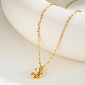 Macro shot of gold stainless steel necklace with sparkling cubic zirconia heart pendant