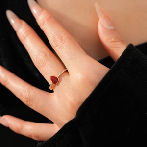 Close-up of 18k rose gold heart ring with red enamel and pavé-set cubic zirconia