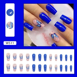 Detail of long coffin press-on nails featuring blue butterfly art and glossy finish