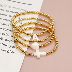 Handmade beaded bracelet set with gold beads, white heart, cross, and letter A charms