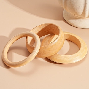 Three-piece set of vintage wooden geometric open bangles with natural light grain finish
