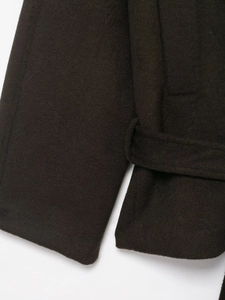 Details von dunkelbraunem Wolljackenärmel mit hochwertiger Stoffstruktur und Gürtelschlaufe