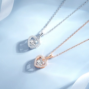 Silver and rose gold infinity heart necklaces with moissanite on a blue background