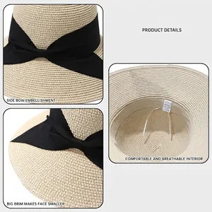 Women's foldable beige straw sun hat with wide brim and elegant black bow ribbon detail