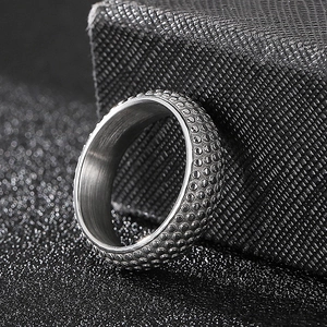 Macro shot of men's titanium steel ring with textured dots and brushed inner band