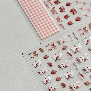 Detail view of cute nail art stickers with strawberry, rabbit, and rose patterns