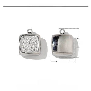 Macro detail of square stainless steel charms with crystal pavé and mirror finish