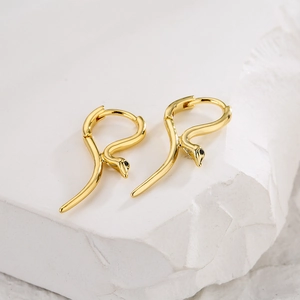 Eleganti orecchini a cerchio a serpente in rame placcato oro 18K con zirconi su marmo