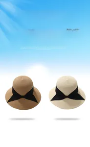 Close-up of finely woven straw hats with black ribbons in beige and brown colors
