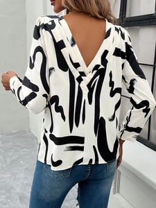 Detail of white printed long-sleeve blouse featuring an elegant V-shaped open back design