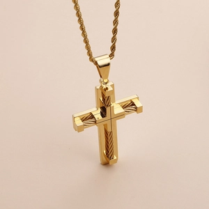 Detail view of a gold-colored cross pendant with wire texture and twisted rope chain